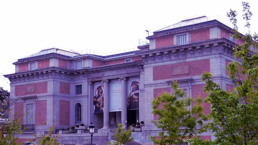 Fachada principal del Museo Nacional del Prado en Madrid con lonas de exposición