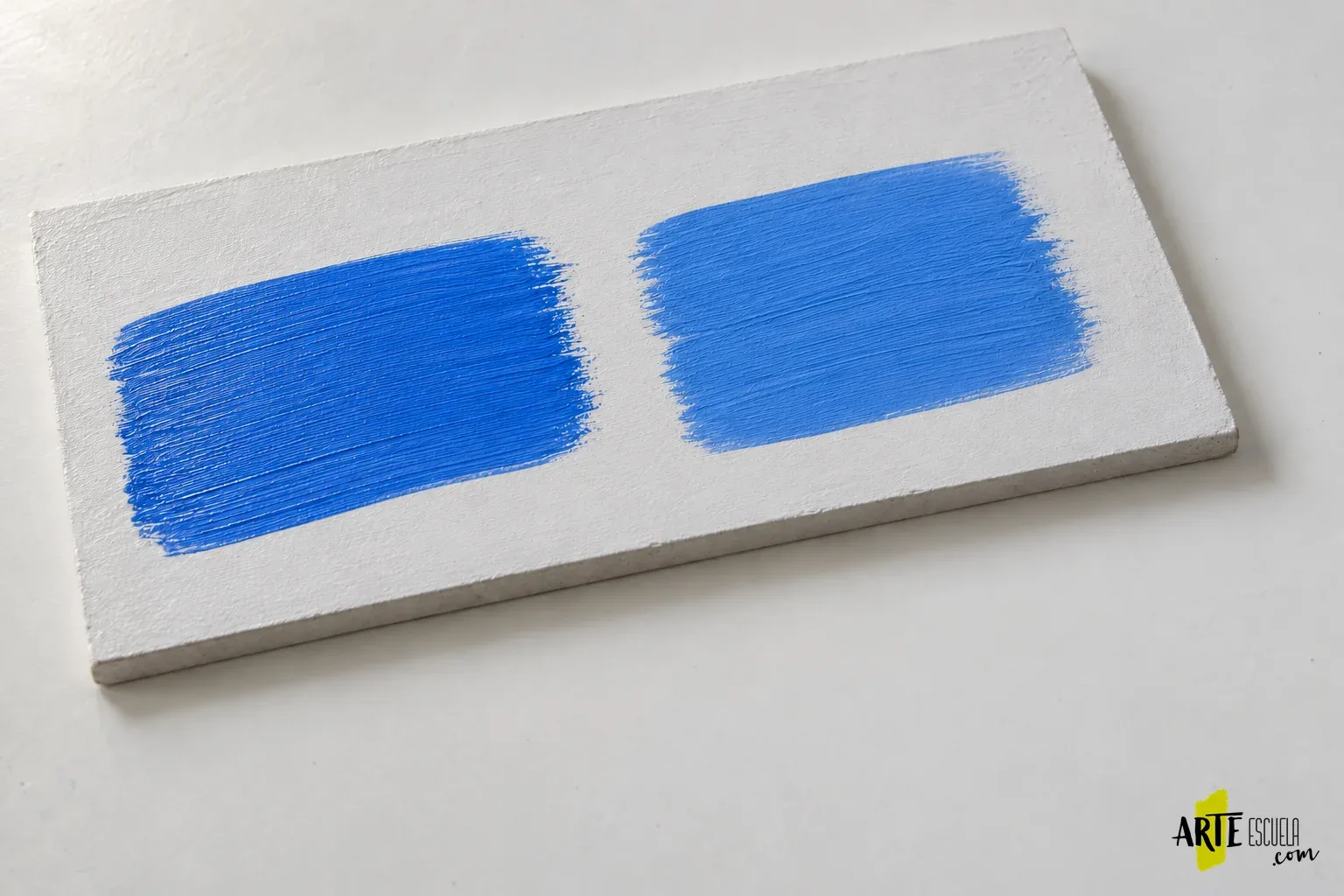 El acrílico sigue pegajoso: qué revisar antes de dar otra capa o barnizar Dos aplicaciones azules separadas en un soporte de prueba para comparar pintura sola y mezcla compatible