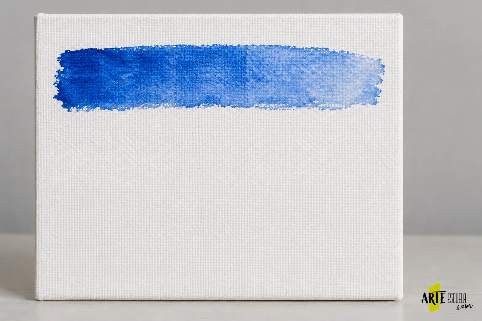 ¿Se puede pintar acuarela sobre lienzo? Preparación y prueba de una muestra Lavado horizontal azul sobre un lienzo preparado, con la trama visible bajo el pigmento