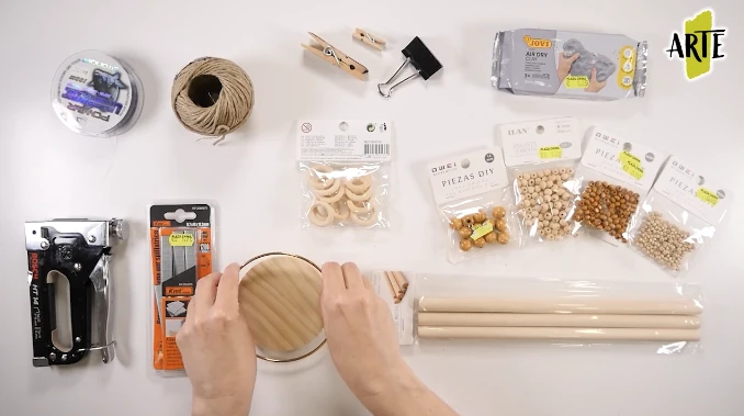 Cuerda, cuentas de madera, aros, palos, hilo y herramientas preparados para construir la percha móvil