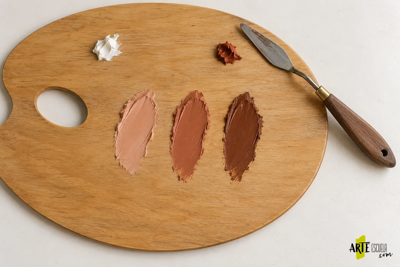 Paleta para óleo: cómo preparar la superficie y comparar tus mezclas sin perder pintura Tres mezclas de óleo, clara, media y oscura, separadas sobre una misma paleta de madera